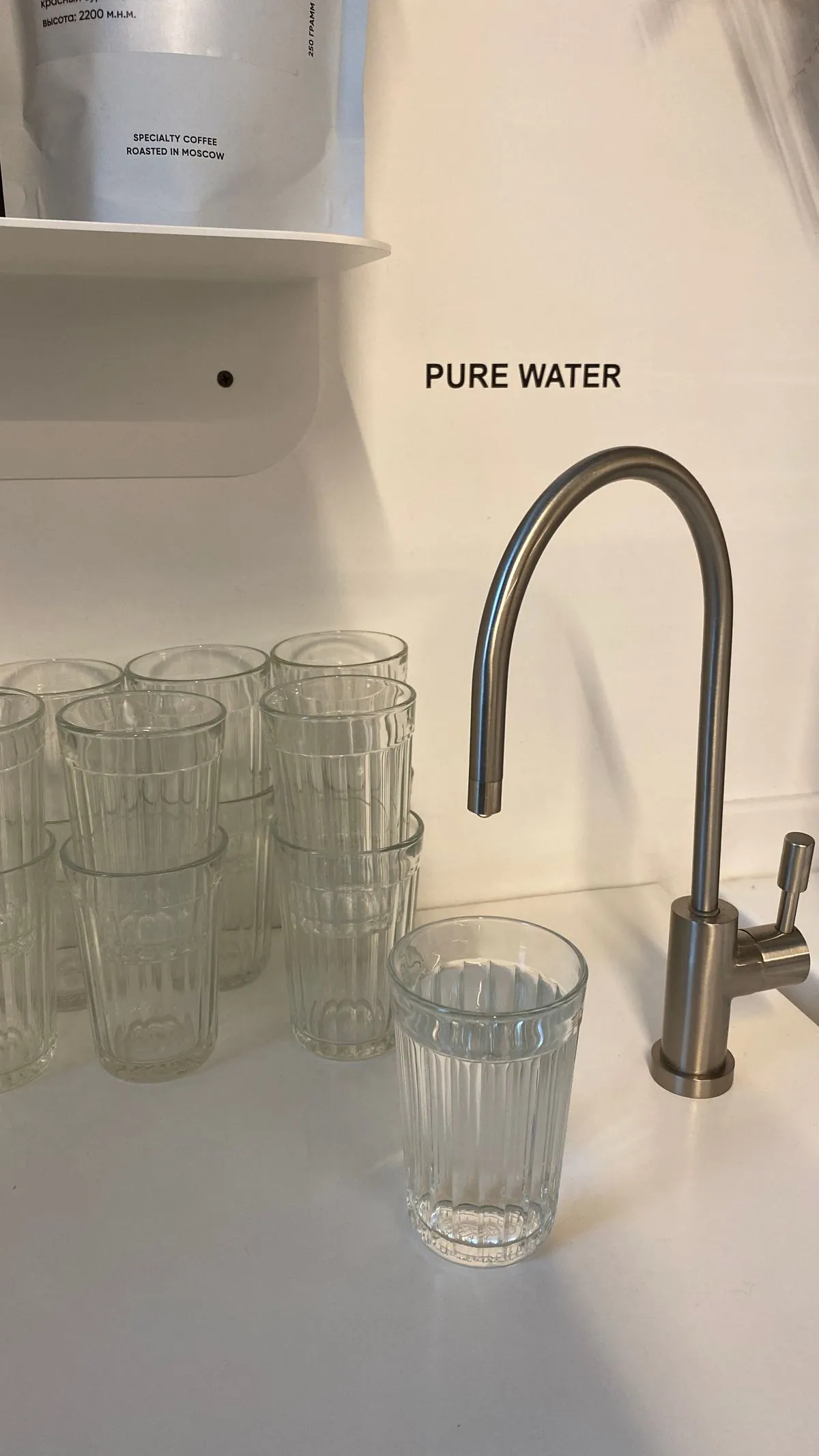A clear glass of water filled from a faucet
